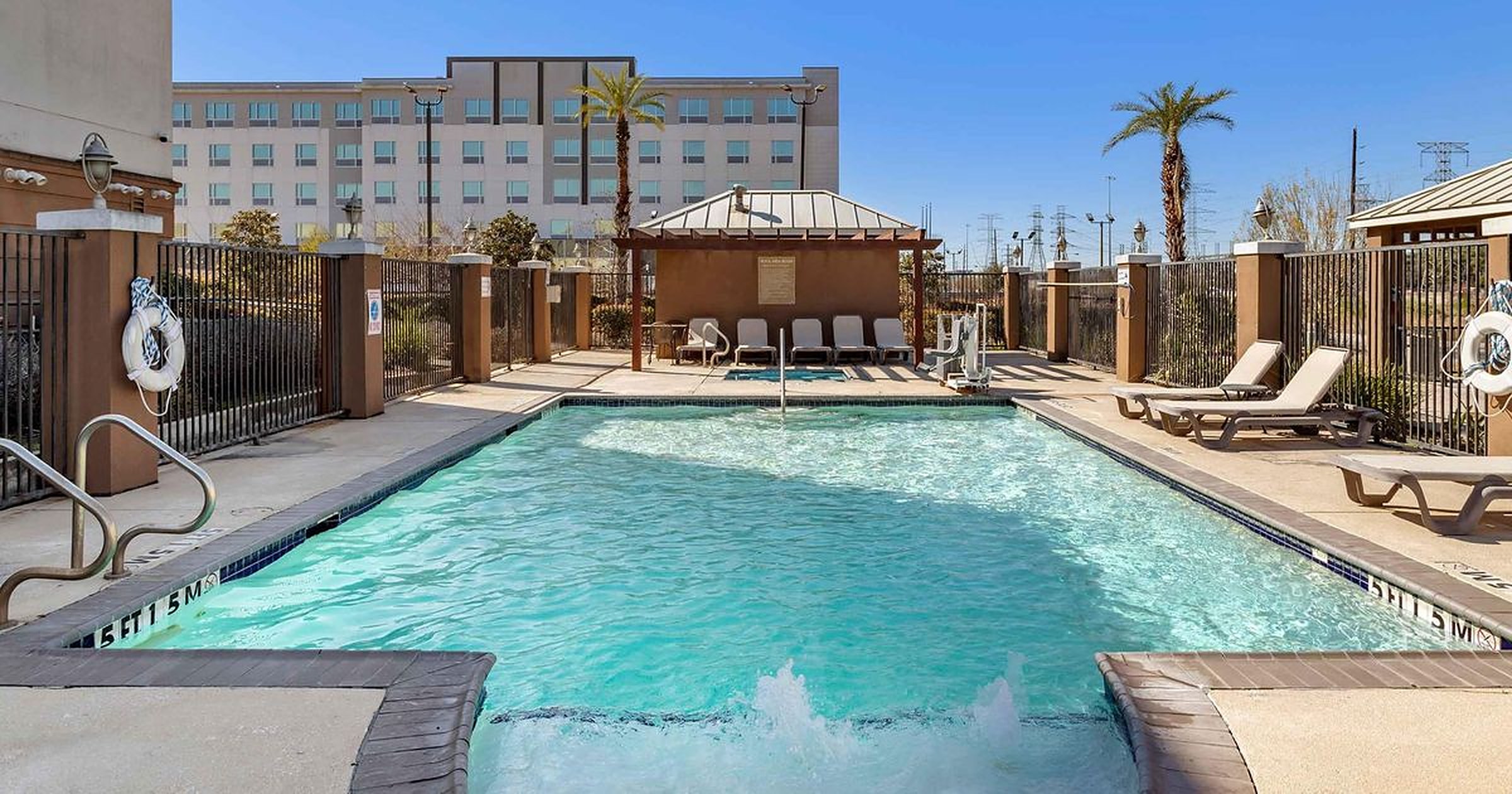 Outdoor pool with loungers and a shaded cabana